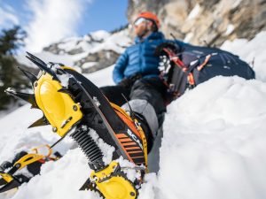 a man laying in the snow with a snowboard attached to his feet